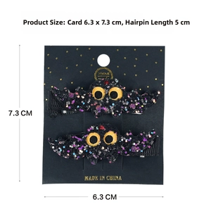 Detail of bat-themed Halloween hair clips with glitter texture and yellow eyes