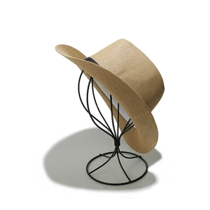 Detailed close-up of woven straw fedora hat texture and black decorative ribbon band