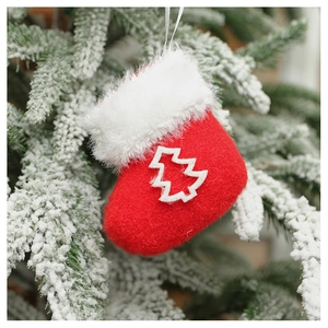 Felt red Christmas stocking ornament with tree applique hanging on a snowy branch