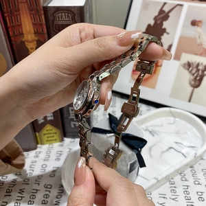 Détail d'une montre en acier argenté avec chiffres romains et couronne sertie