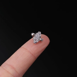 Macro view of a 20G fan-shaped cubic zirconia ear stud placed on a fingertip