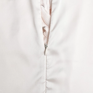 Detail view of pink satin dress featuring lace-up back design and hidden zipper closure