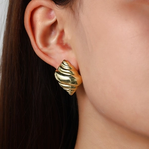 Modern 18k gold plated conch spiral stud earring on female ear with metallic luster