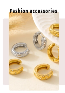 Detailed view of chunky gold and silver hoop earrings with starburst zircon engraving