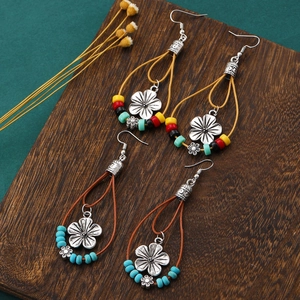 Detail of bohemian drop earrings with turquoise beads and retro floral silver charms