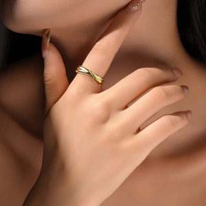 Close-up of golden crossover ring with a micro-diamond worn on a woman's finger