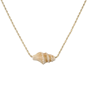 Detailed close-up of a golden bead chain necklace with a natural conch shell pendant