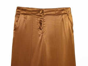 Detail of high waist satin trousers with four elegant button closure and glossy fabric