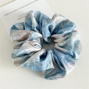 Detailed view of the tie-dye satin fabric hair scrunchie with blue and pink marble texture