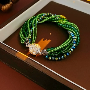Détail du bracelet multicouche en perles vert émeraude avec fermoir en strass en boîte