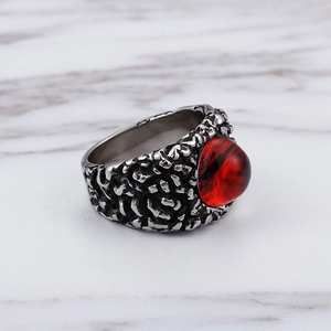 Gothic vintage stainless steel ring with red ruby eye stone on marble background