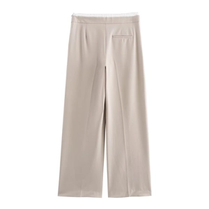 Detailed view of the double-layer high waist and side pockets on beige wide-leg trousers