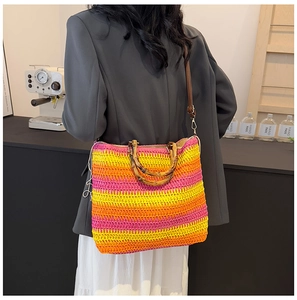 Detail of colorful woven straw tote with bamboo handles and adjustable shoulder strap