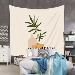 Detail of bohemian tapestry featuring green palm leaves and abstract beige shapes on a wall