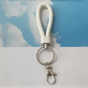 Detailed view of white braided leather keychain with silver lobster clasp and metal ring