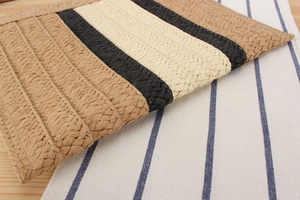 Detail of hand-woven paper rope bag with tricolor striped pattern on a wooden table