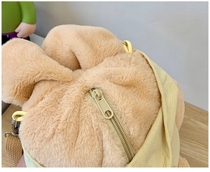 Close-up of the plush poodle backpack featuring zipper closure and yellow canvas strap