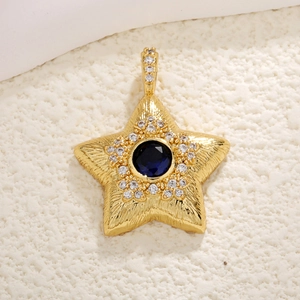 Detailed view of a gold star pendant with center blue gem and textured metal finish