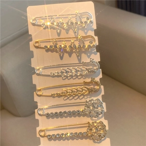 Detailed set of six decorative safety pins in gold and silver with heart and feather designs