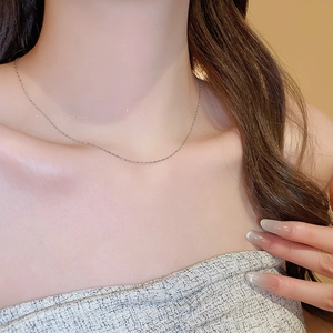 Close-up of minimalist stainless steel water drop chain necklace worn on a model