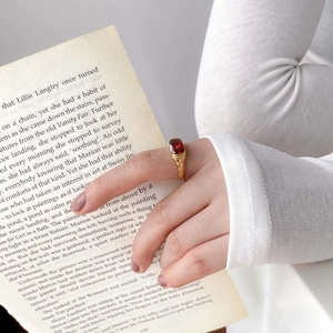 Minimalist gold ring with square red gemstone featuring vintage texture on finger