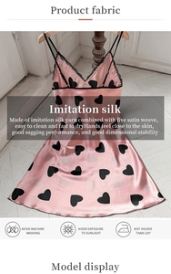 Détail d'une chemise de nuit rose satinée avec motifs cœurs et bordure dentelle
