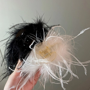 Close-up of black and white fluffy ostrich feather hair claws with gold springs
