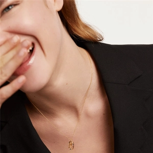 Golden necklace with letter Y pendant featuring colorful zircon stones on a female model