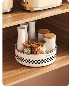 Close-up of rotating spice rack with checkered pattern and ceramic jars in wooden cabinet
