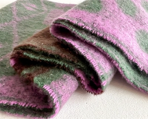 Close-up of thick cashmere-like scarf showing soft wool texture and purple edge stitching