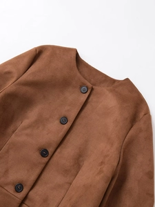 Détail d'une veste en daim marron montrant le col rond et les boutons noirs contrastés
