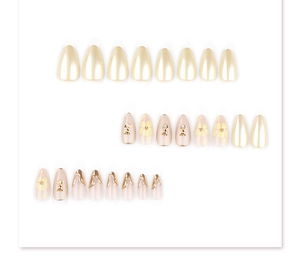 Détails macro de faux ongles amande avec fleurs 3D dorées et ornements métalliques