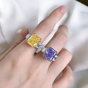 Macro detail of yellow and purple radiant cut rings with side stones on a silver band