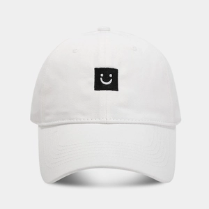 Gros plan d'une casquette blanche en coton avec broderie smiley carrée noire