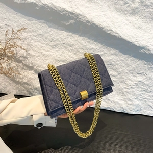 Classic blue denim quilted crossbody bag with a gold chain strap and metal lock closure