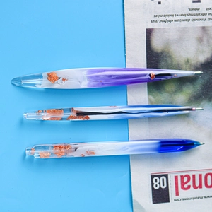Detailed view of DIY resin ballpoint pens with gradient glitter and gold foil accents