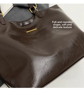 Detailed close-up of dark brown tote bag with high-gloss leather texture and gold hardware