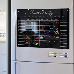 Close-up of magnetic acrylic monthly calendar board on fridge with 6 colored markers