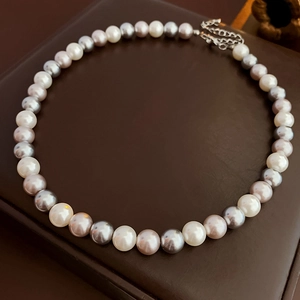 Detail of multi-color pearl necklace with silver lobster clasp and extension chain