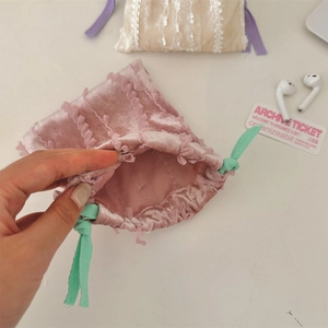 Detailed shot showing the soft pink velvet texture and lace trim of the drawstring pouch
