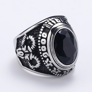 Foto macro de anillo punk con piedra negra tallada y banda plateada grabada con relieves