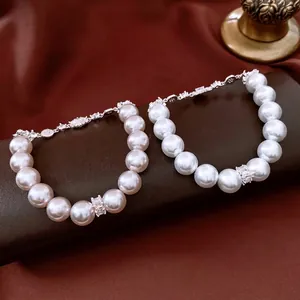 Elegant pearl bracelets with zircon flower charms on dark red silk background display
