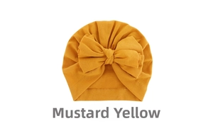 Detail view of ginger yellow baby turban hat with a large soft decorative bow