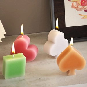 Artistic poker suit candle set featuring heart, club, spade, and diamond shapes on wood