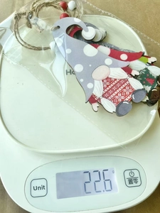 Weight measurement of wooden Christmas gnome ornaments set showing approximately 22.6g