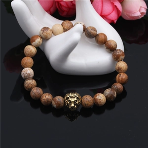 Agate stone bead bracelet with golden lion head charm on reflective black display