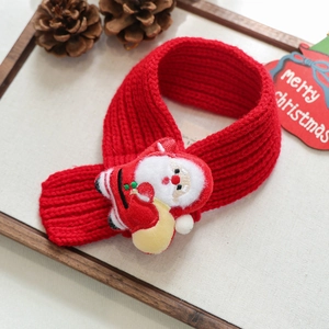 Detail of red knit pet scarf with 3D Santa Claus doll on a rustic wooden tray