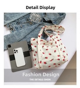 Detailed texture of white corduroy tote bag with red and green strawberry prints