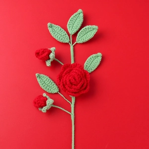 Vista dettagliata di una rosa rossa fatta a maglia a mano con gambo verde su sfondo rosso