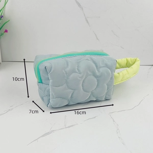Detail of light blue quilted makeup bag showing 16x7x10cm dimensions and green zipper